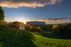 Allianz Arena München mit Kirche vom Müllberg in der goldenen Stunde